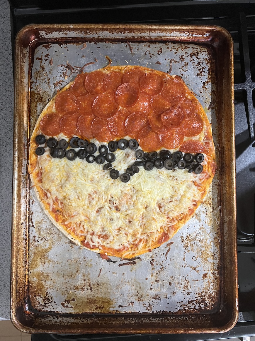A pizza topped to look like a Pokéball